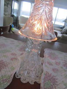 a glass table lamp sitting on top of a wooden table