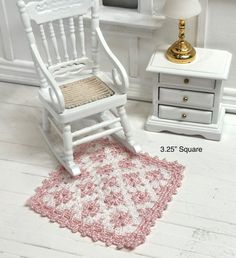 a white rocking chair sitting next to a lamp