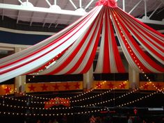 a large red and white tent with lights around it