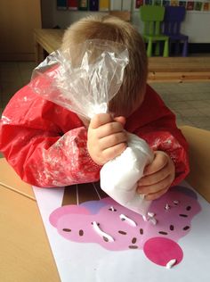 a little boy sitting at a table with doughnuts on it's face