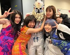 four young women posing for a photo in front of a statue