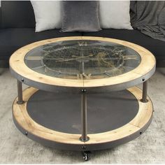 a coffee table with wheels on it in front of a black couch and white pillows