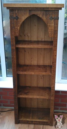 an old wooden bookcase in front of a window