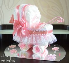 a pink and white baby's carriage cake on a table