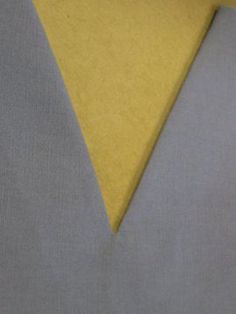 a yellow and grey necktie with a white pocket square on the left hand side