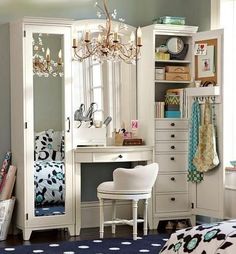 a bedroom with a desk, mirror and dressing room furniture in it's corner