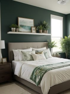 a bedroom with green walls, white bedding and potted plants on the wall