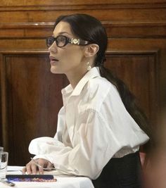 a woman wearing glasses sitting at a table