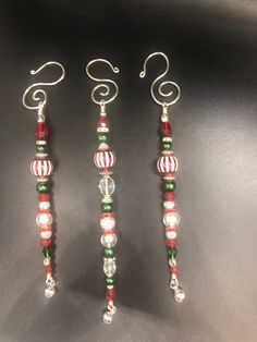 three christmas beaded earrings on a black surface with silver earwires and red, green and white beads