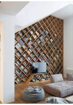 a living room filled with furniture and bookshelves next to a wall full of books