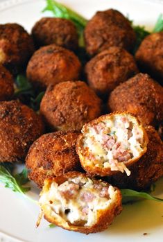 some meatballs on a white plate with greens