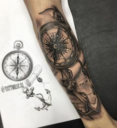 a man's arm with a compass and an anchor tattoo on the left forearm