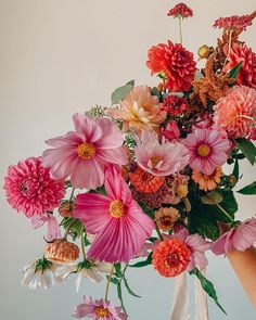 a vase filled with lots of different colored flowers