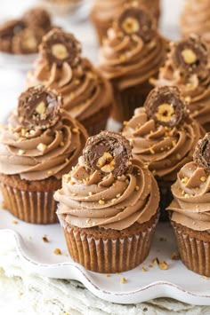 cupcakes with chocolate frosting and sprinkles on a white plate