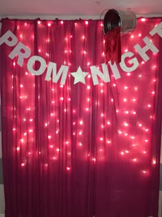 a red curtain with the word prom night written on it and some lights behind it