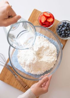 someone mixing ingredients in a bowl on a cutting board