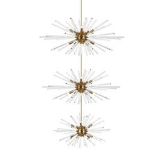 three starburst chandelier hanging from the ceiling in gold, white and clear