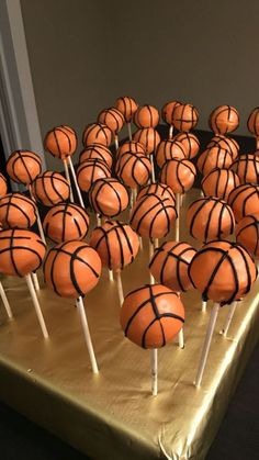 there are many basketballs on the table with sticks in front of them and one is orange