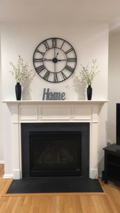 a living room with a fireplace and clock on the wall