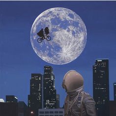 a man in an astronaut's suit is looking at the moon and bicycle rider