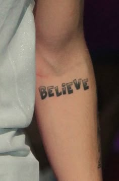 a person with a tattoo that says believe