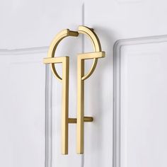 an image of a door handle that is on the side of a white door with gold trim