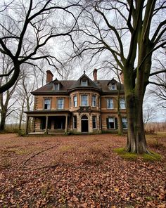 an old house surrounded by trees and leaves