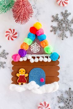 a gingerbread house made out of candy canes and snowflakes on a marble surface