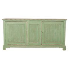 a green cabinet with three doors and two drawers on one side, against a white background