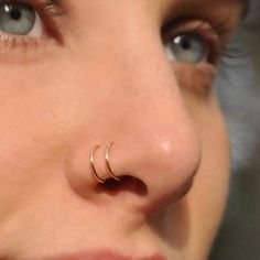 a close up of a person with a nose piercing in their left eye and lines on her right side