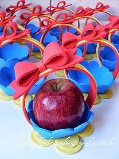 an apple in a cupcake holder with red bows