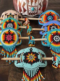 several colorful beaded items sitting on top of a wooden table