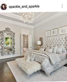 a bedroom with a bed, mirror and chandelier in the middle of it