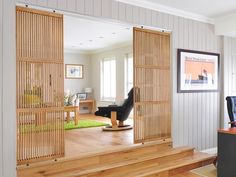 an open door leading to a living room with wood flooring and white painted walls