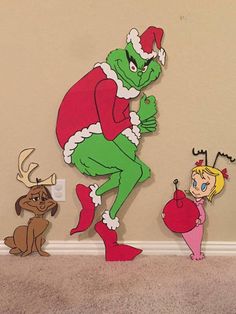 the grinch and little miss piggy are standing next to each other in front of a wall