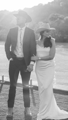 a man and woman standing next to each other in front of a body of water