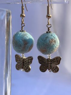 Bring some zing to your next Zoom with these adorable sky blue and tan felted wool bead earrings with silver-tone butterfly at the bottom. Delicate bead cap completes the look. Wool beads hang gracefully from silver tone ear wires. Unique and unusual! Wool beads are made by intricately wrapping wool roving in carefully selected colors and then wet felting each one through an iterative immersing and rolling process. Each wool bead is unique, selected specifically for each piece. Minding My Own Business, Earring Tutorial, Wet Felting, Butterfly Earrings, Felted Wool, Bead Caps, Bead Earrings, Ear Wires, Wool Felt