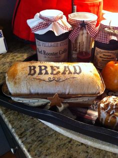 bread and jams are sitting on the counter in front of an old fashioned bread sign