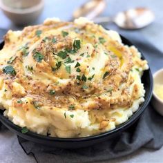 mashed potatoes in a black bowl with parsley on top