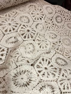 an old lace doily is laying on top of a tablecloth with crochet