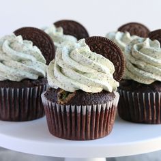 chocolate cupcakes with white frosting and oreo cookies on the top one