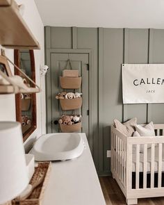 a baby's room with a white crib and wooden floors, painted in pale green