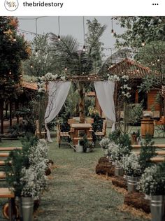 an outdoor wedding setup with white draping and greenery on the arbors