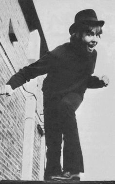 a man on a skateboard in the air with his arms out and feet apart