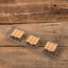 four pieces of cake sitting on top of a metal rack next to wooden planks