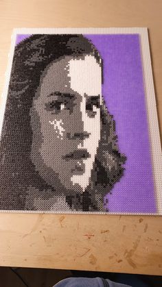 a close up of a person's face on a piece of art made out of legos