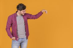 a man pointing at something with his right hand on an orange and yellow background in front of him