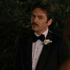 a man in a tuxedo and bow tie looking at the camera with an intense look on his face