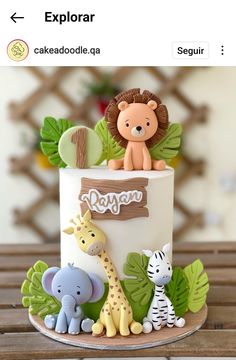 a birthday cake decorated with jungle animals and giraffes