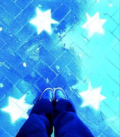 the person is standing in front of stars on the ground with their feet up and legs crossed